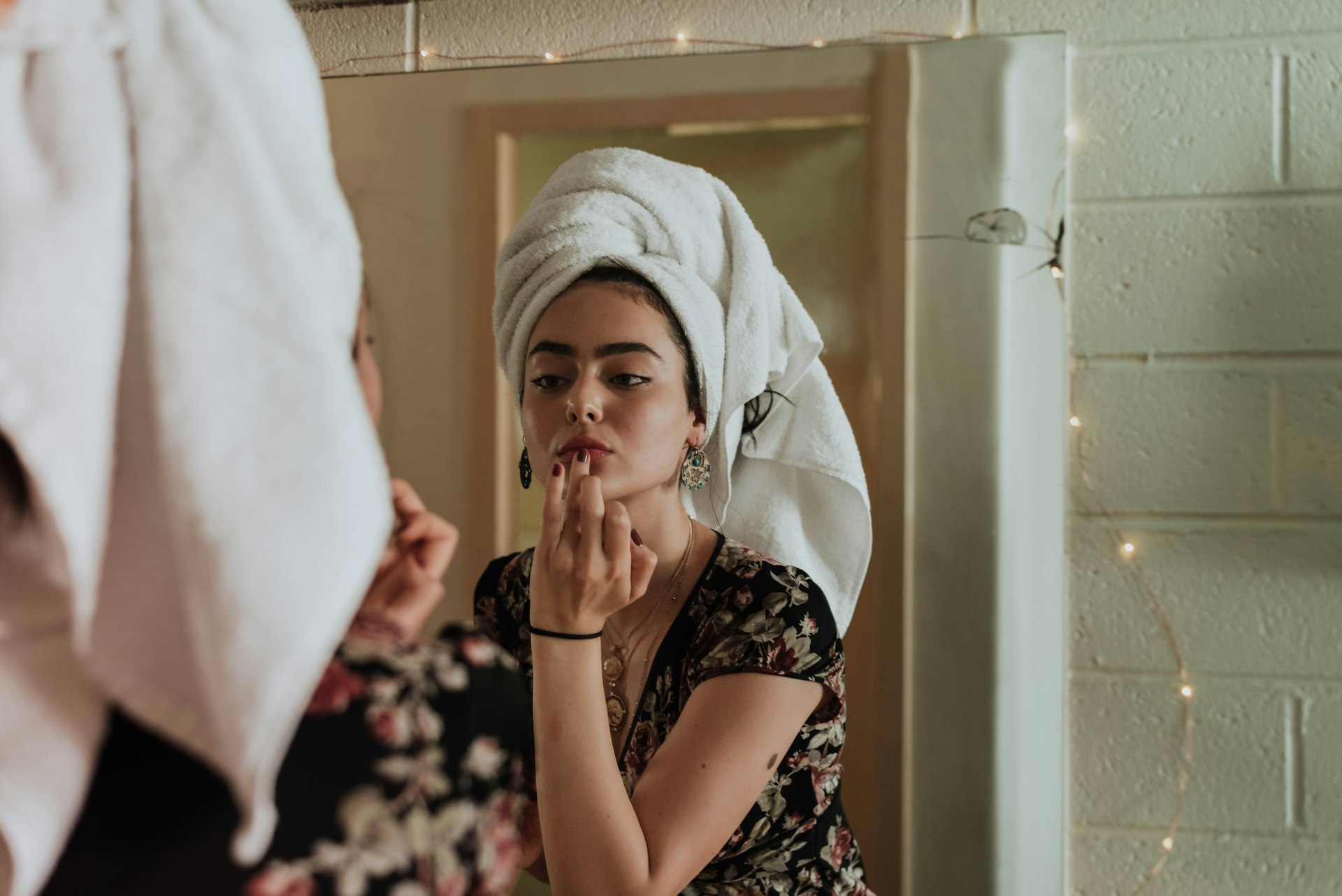 xxxx woman putting makeup in front of mirror